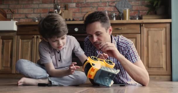 パパと息子が一緒におもちゃの車を修理する — ストック動画