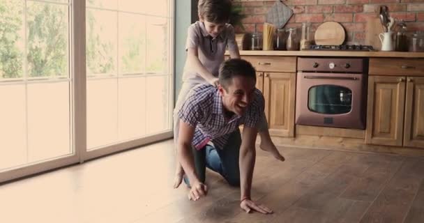 Ребенок скачет на папочке и играет вместе на кухне. — стоковое видео