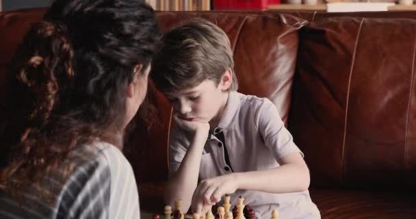 Мальчик играет с мамой в шахматы — стоковое видео