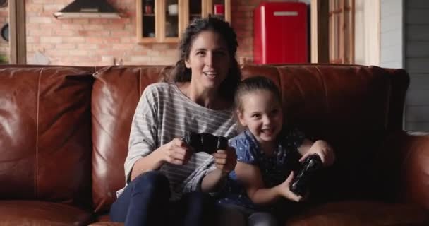 Mam spelen video games console met weinig leuke dochter — Stockvideo