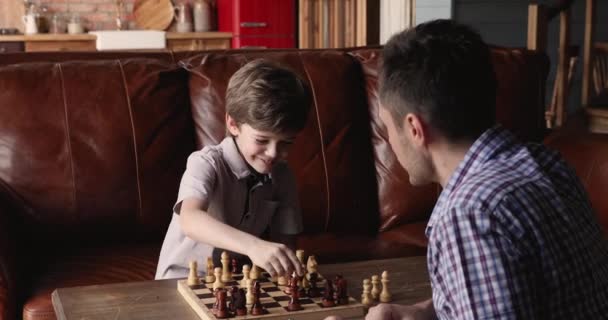 Отец и сын проводят время вместе дома, играя в шахматы. — стоковое видео