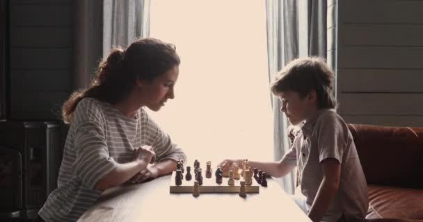 Liebevolle Mutter bringt Sohn zu Hause Schach bei — Stockvideo