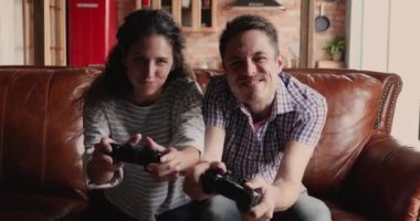 Çift kanepede oturup video oyunları oynuyor.