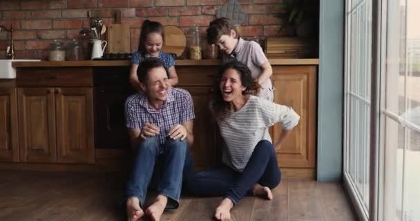 Crianças cócegas pais jogar juntos na cozinha moderna aconchegante — Vídeo de Stock