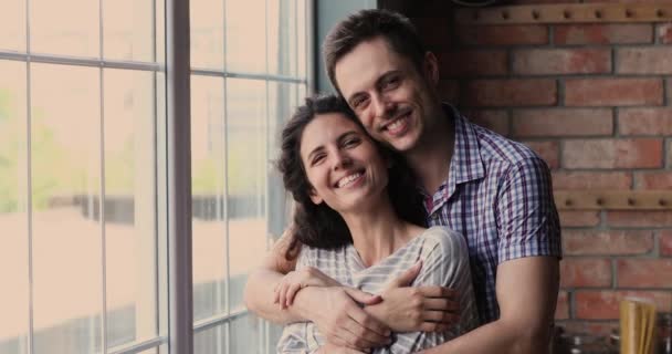 Pareja abrazando de pie en el interior sonriendo mirando a la cámara se siente feliz — Vídeos de Stock