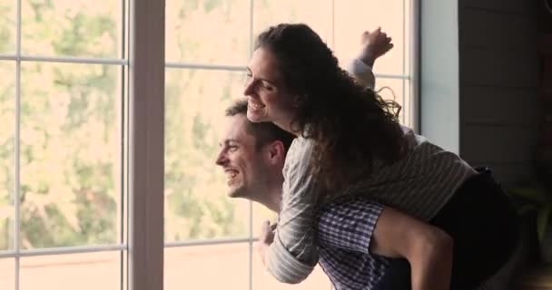 Żona na barana mąż śmieje się zachować ramiona wyciągnięte marząc przyszłe podróże — Wideo stockowe