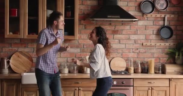 Pareja alegre cantar una canción bailando en la cocina — Vídeos de Stock