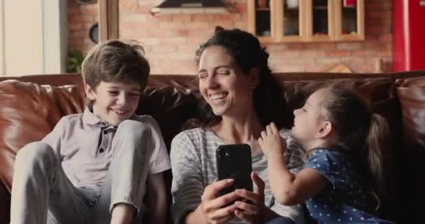 Mamá y los niños se divierten usando la aplicación en el teléfono inteligente — Vídeo de stock