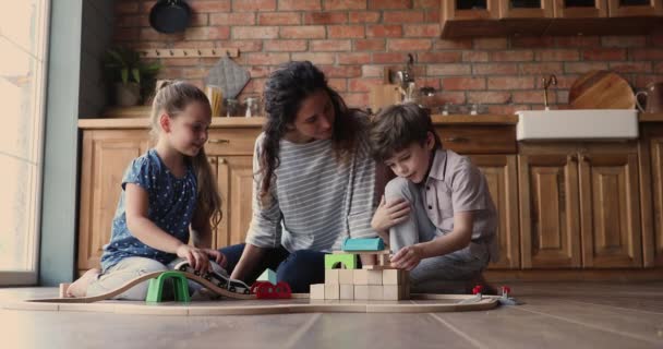 Família joga em casa com ferrovia de brinquedo e blocos de madeira — Vídeo de Stock