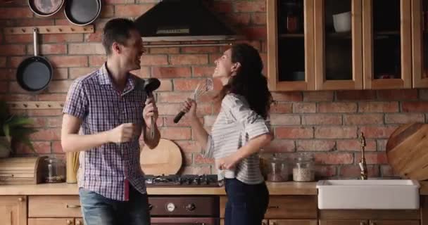 Spouses dancing singing song holding kitchen utensils like microphones — Stock Video