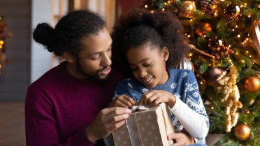 Afrika kökenli Amerikalı baba ve kız Noel hediyelerini boşaltıyorlar.