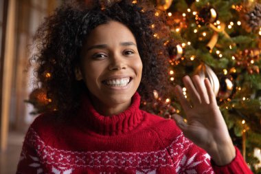 Gülümseyen Afrikalı Amerikalı kadın el sallıyor, Noel 'i kutluyor.