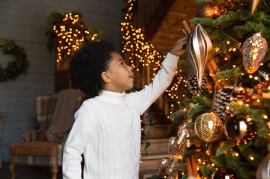 Noel ağacı süsleyen Afrikalı Amerikalı küçük çocuğu kapat.