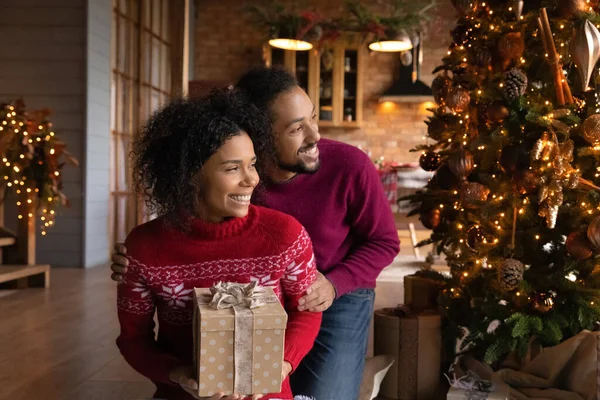Rüya gibi gülümseyen Afrikalı Amerikalı çift sarılıyor, Noel dileği diliyor. — Stok fotoğraf
