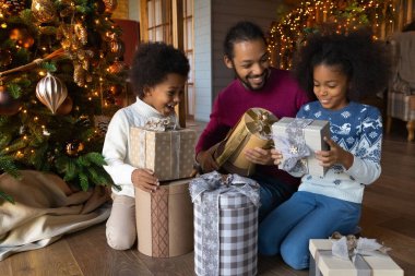 Neşeli Afrikalı Amerikalı aileyi Noel hediyelerini açarken kapatın.