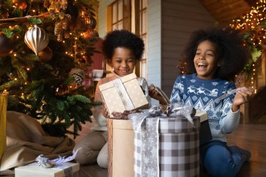Neşe dolu Afrikalı Amerikalı çocukları Noel hediyelerini açarken kapat.