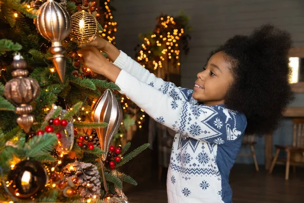 De cerca sonriente chica afroamericana colgando bolas, árbol de decoración — Foto de Stock