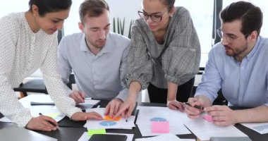 Pazarlama istatistiklerini analiz eden karışık ırk meslektaşları.