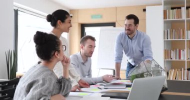 Genç ve karışık ırk profesyonellerinden oluşan mutlu bir ekip proje üzerinde çalışıyor..