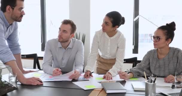 Konzentrierte junge multiethnische Mitarbeiter, die auf qualifizierte männliche Führungskräfte hören. — Stockvideo