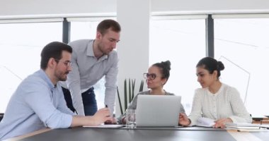 İş sunumu üzerinde çalışan konsantre genç melez meslektaşlar.