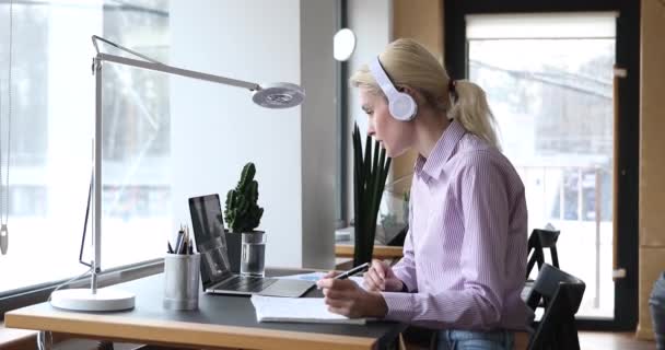 Joven hermosa mujer rubia estudiando remotamente en cursos en línea. — Vídeos de Stock