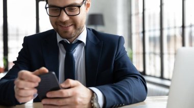 Gözlüklü mutlu genç işadamı akıllı telefon kullanıyor..