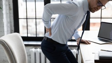 Belinde acı çeken sağlıksız genç bir ofis çalışanı..