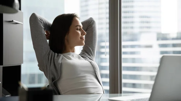 Femme d'affaires millénaire calme rêvant assis au bureau dans la pose détendue — Photo