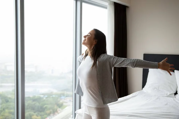 Wisatawan wanita yang riang mengagumi pemandangan dari jendela panorama hotel — Stok Foto