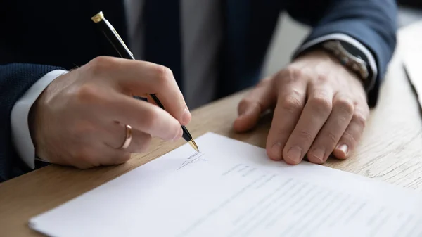 Primer plano joven empresario firma contrato en papel. — Foto de Stock