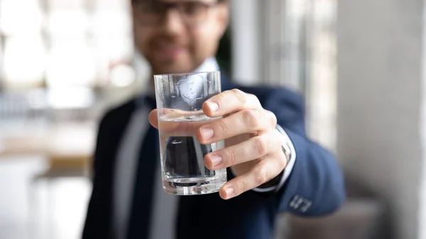 Young entrepreneur reaching out hand with glass of water.