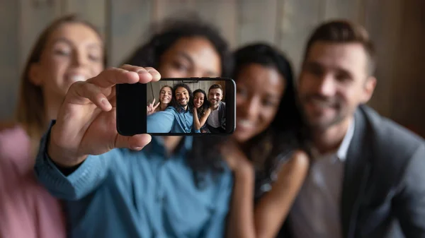 Quattro diversi amici millenari multietnici che mostrano selfie spettatore su smartphone — Foto Stock