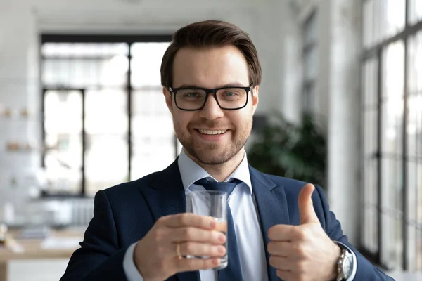 Счастливый молодой сотрудник держит стакан воды в руках. — стоковое фото