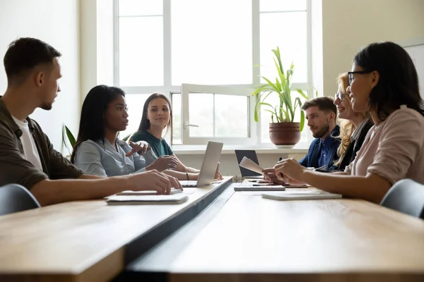 Diverse business team sitting in meeting room discussing project