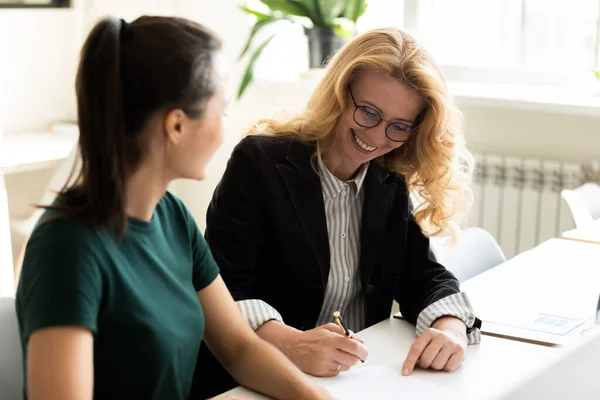 Satisfied older and younger female business partners concluding agreement — Stock Photo, Image