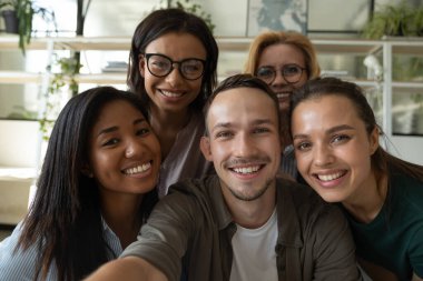 Çeşitli meslektaşların selfie çektiği mutlu bir gülüş takımı.