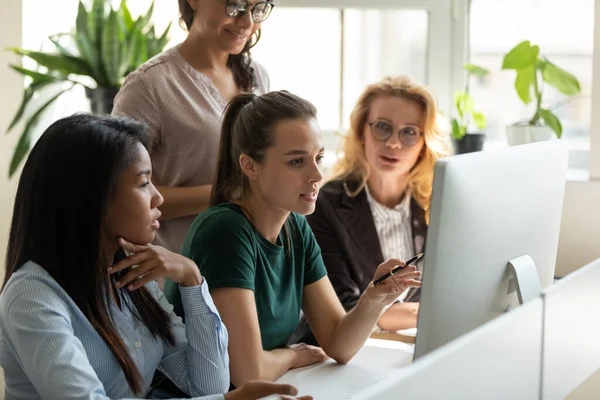 Olika kvinnliga kontorsanställda tittar på datorskärm lyssna utbildare — Stockfoto