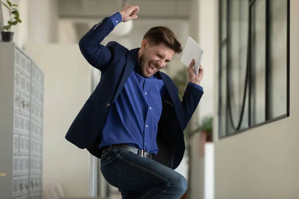 Euphoric male executive jumping at office hallway getting career growth — Stock Photo, Image