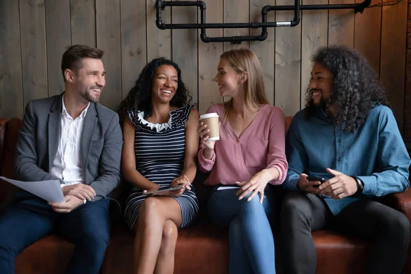 Compagnie diversifiée de coéquipiers millénaires ayant une réunion informelle au café — Photo