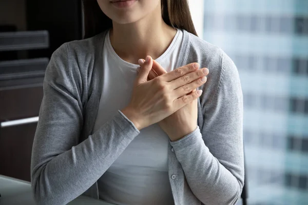 Young woman hands folded on chest expressing heartfelt thank you — Stock Photo, Image