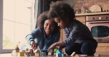 Afrikalı bir anne küçük kızıyla tahta bloklar oynuyor.