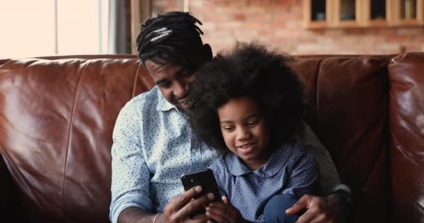 Africano pai passar tempo com a filha se divertindo usar smartphone — Vídeo de Stock