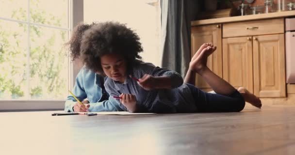 Afrikaanse familie liggend op de vloer tekenen foto 's in schetsboek — Stockvideo