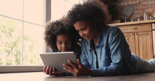 非洲妈妈和小孩躺在室内玩平板电脑 — 图库视频影像