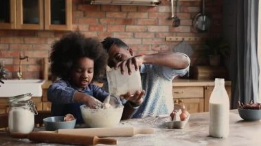 Afrikalı kız hamur yoğurur. Babasıyla mutfakta yemek pişirir.