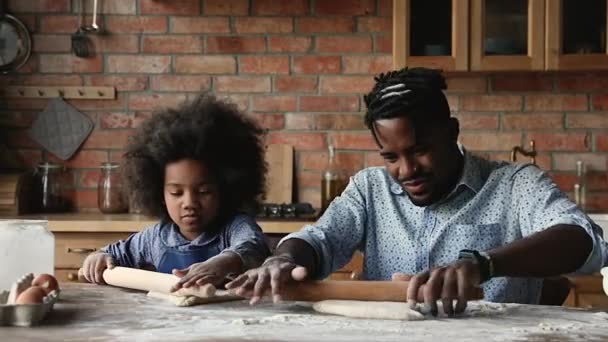 Afrikaanse vader en dochter plat deeg voor taart in de keuken — Stockvideo