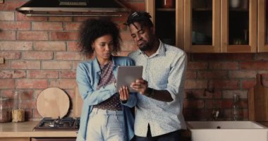 Afrikalı çift evdeki mutfakta dururken tablet kullanıyor.
