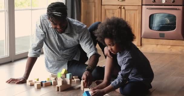 Africano papá pequeña hija jugando juntos sentarse en cocina piso — Vídeos de Stock