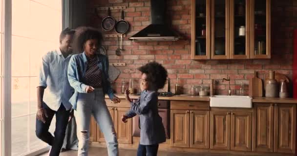 Afrikaans koppel en dochtertje dansen in moderne gezellige keuken — Stockvideo